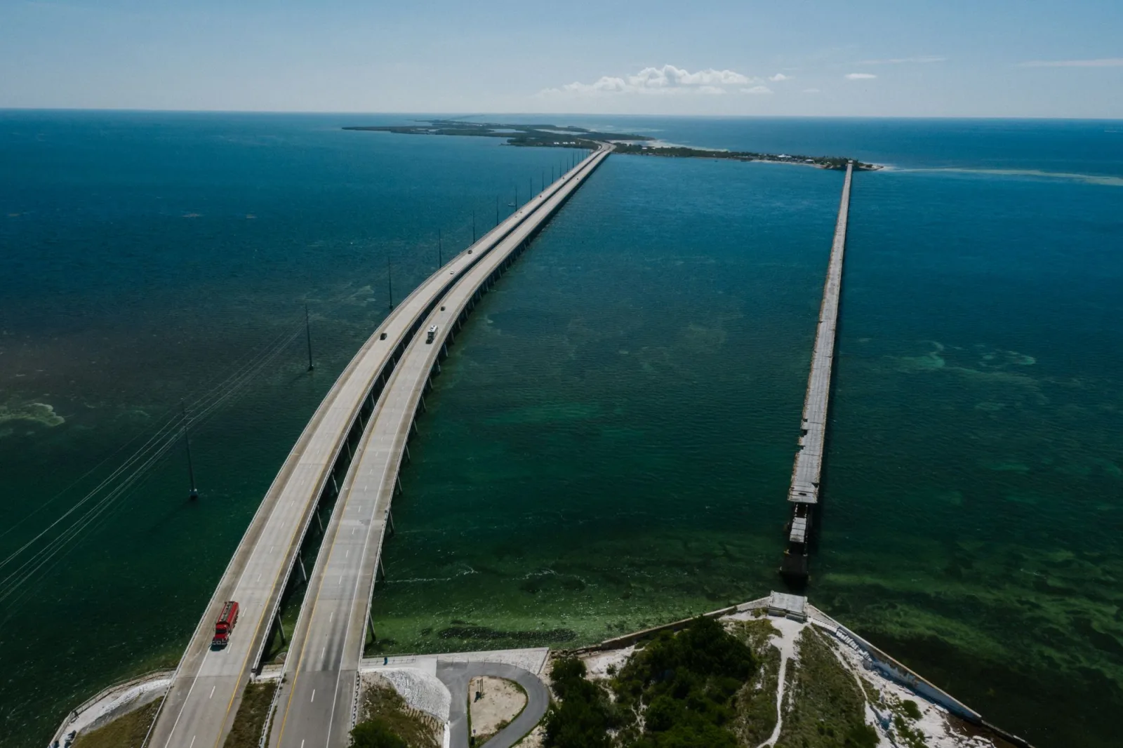 Aerial view of the Seven Mile Bridge carrying US-1 across shallow green and blue water, with the old bridge running parallel
